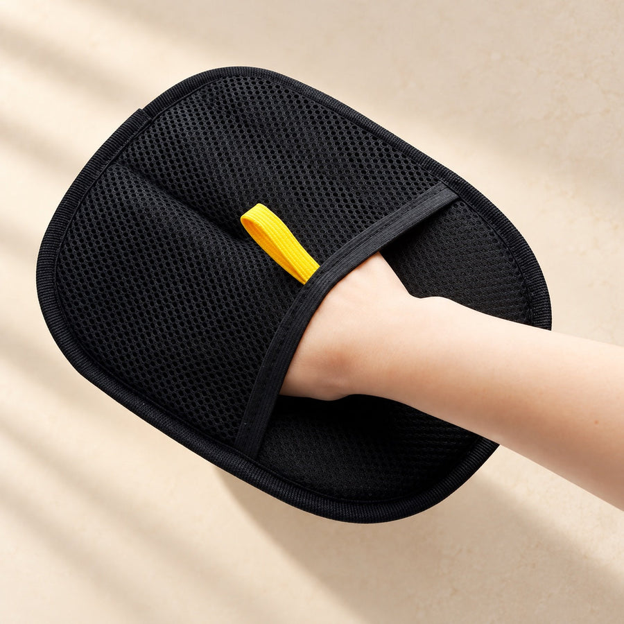 The Everyday Mitt: a black mesh mitt with a yellow pull tab, worn on a hand.