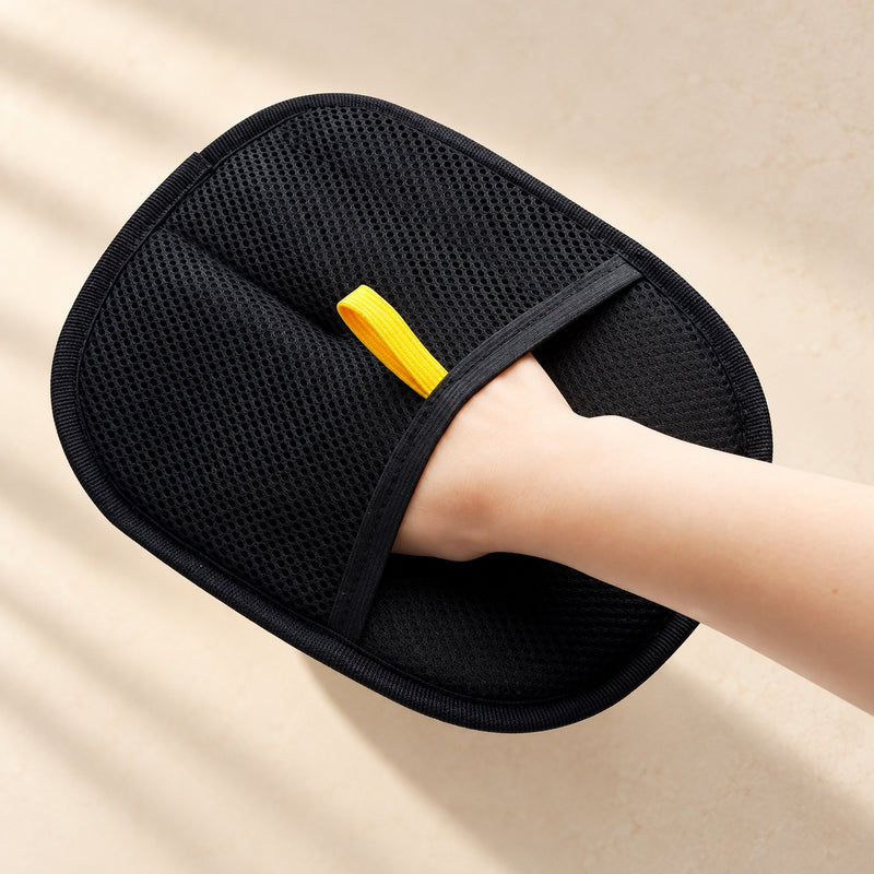 The Everyday Mitt: a black mesh mitt with a yellow pull tab, worn on a hand.